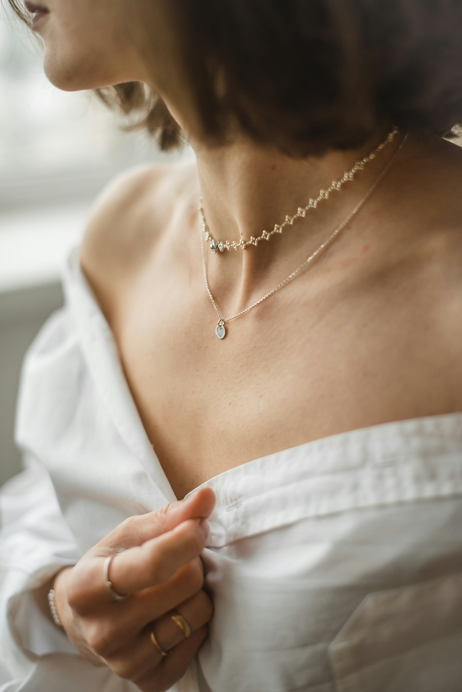 Woman wearing dainty layered sterling silver necklaces