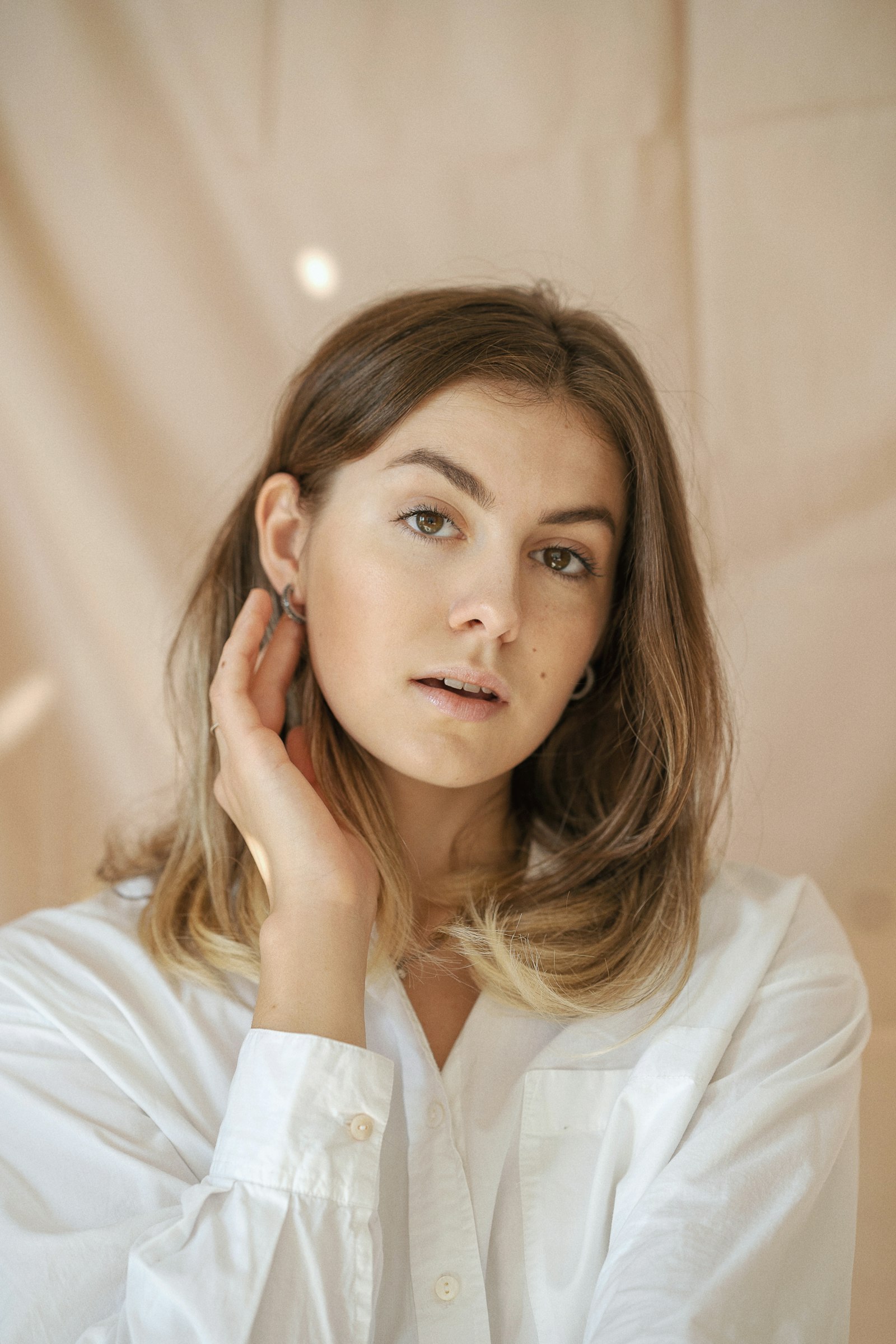 Woman touching her ear showing small hoop earrings