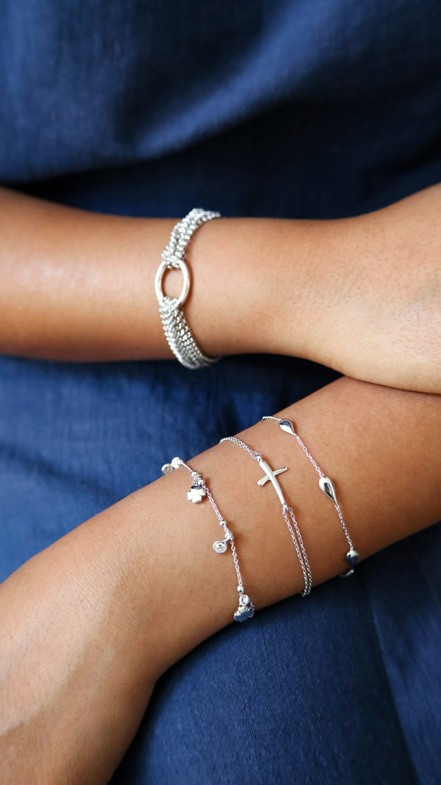 Delicate silver bracelets worn on both wrists