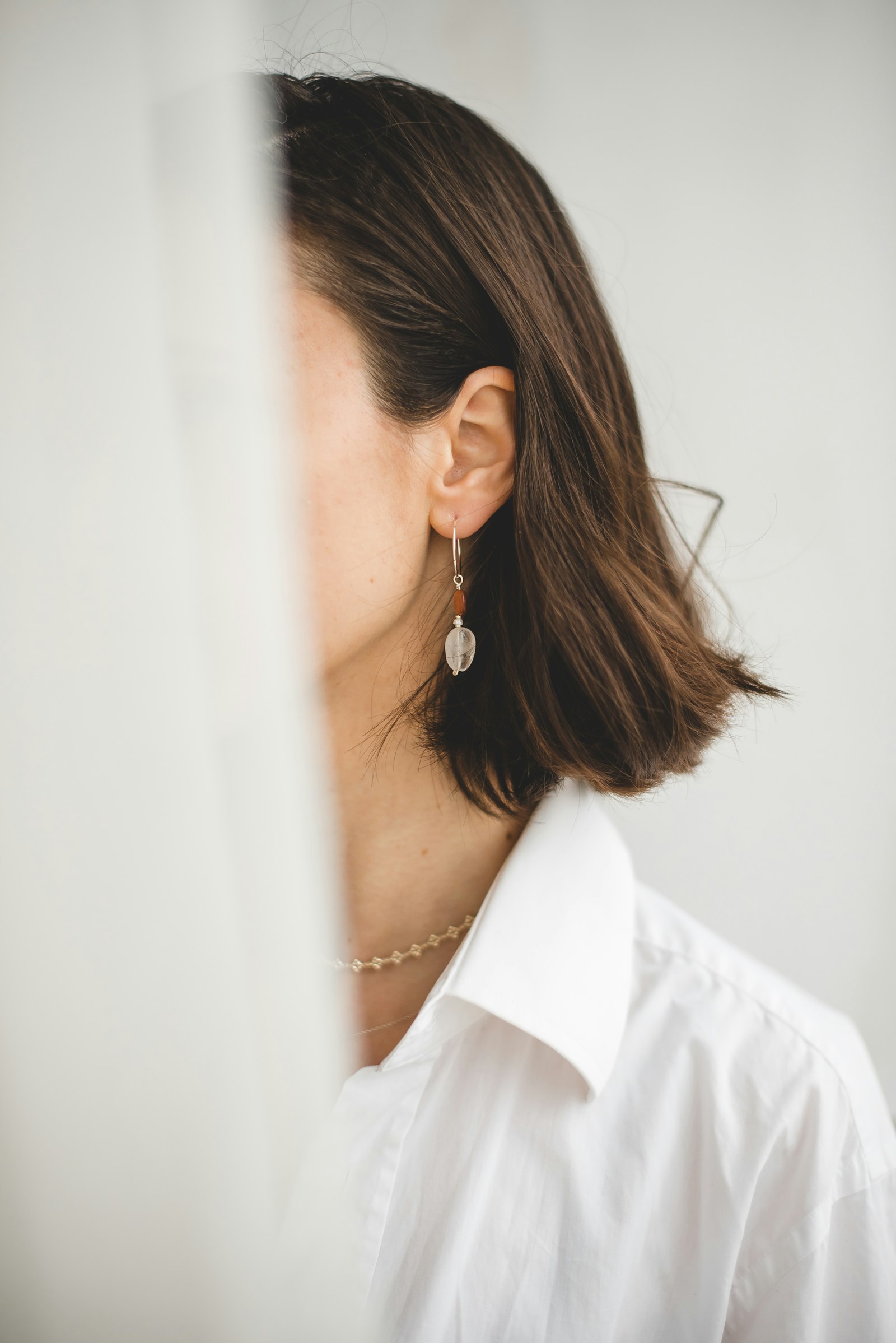 Woman wearing delicate sterling silver drop earrings